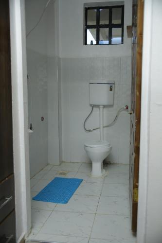 a bathroom with a toilet and a blue rug at Enn lovely apartment 12 in Bungoma