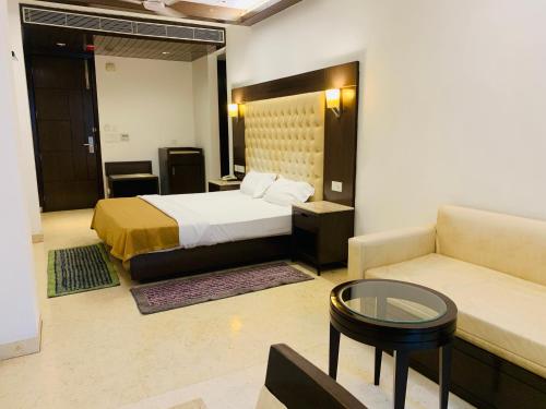 een hotelkamer met een bed en een bank bij Metropolis Tourist Home Paharganj in New Delhi