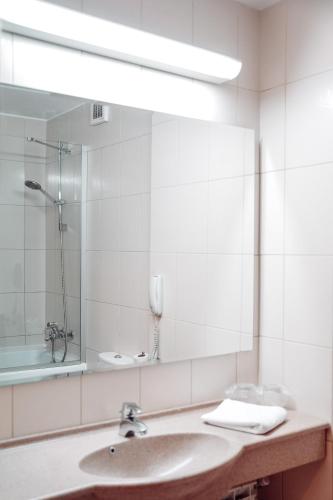 a bathroom with a sink and a mirror at Unirea Hotel & Spa in Iaşi