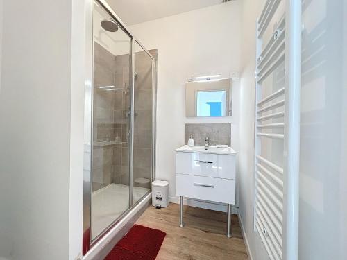 une salle de bain blanche avec un lavabo et une douche dans l'établissement Grand Appartement Central - Trois Chambres - Les Frères de la Loc', à Marseille