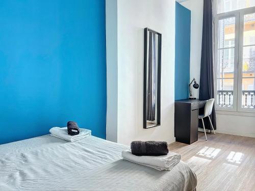 Cette chambre bleue comprend un lit et un bureau. dans l'établissement Grand Appartement Central - Trois Chambres - Les Frères de la Loc', à Marseille