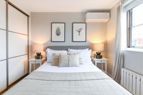 倫敦的住宿－Buckingham and Lloyds - South Kensington，卧室配有一张带两张桌子的大型白色床
