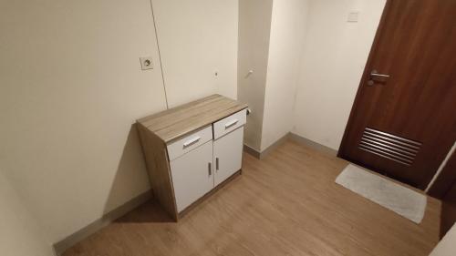 a small room with a wooden cabinet and a door at Apartemen Grand Kamala Lagoon Studio By Bonzela Property in Bekasi