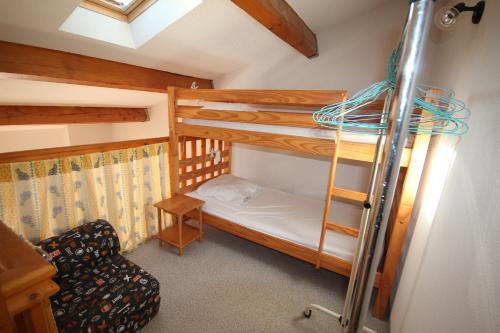 - une chambre avec 2 lits superposés et une chaise dans l'établissement Villa 4 couchages terrasse sud parking piscine commune dans résidence sécurisée à 200m de la mer LRMA34, à Portiragnes