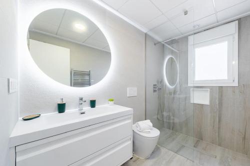 a white bathroom with a sink and a mirror at Palace Torre de la Horadada in Torre de la Horadada