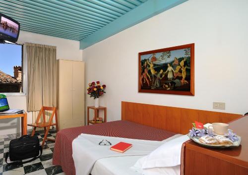 une chambre d'hôtel avec un lit et un tableau sur le mur dans l'établissement Hotel Raffaello - Self Check-in Free, à Urbino