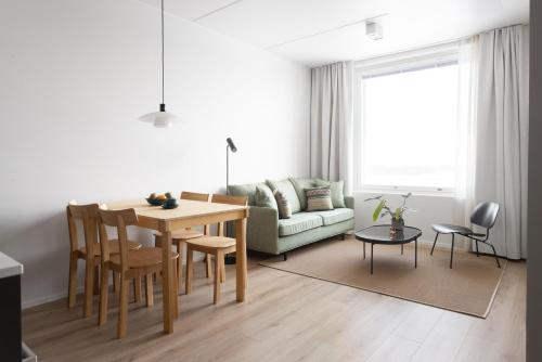a living room with a table and a couch at Noli Otaniemi in Espoo