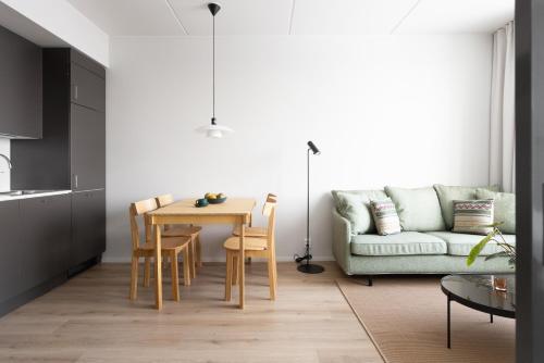 a living room with a table and a couch at Noli Otaniemi in Espoo