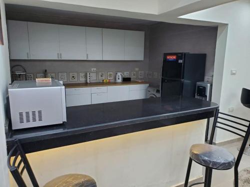 a kitchen with a counter with a microwave and a refrigerator at Stylish 3 bedroom apartment close to the Pyramids and Grand Egyptian Museum in ‘Ezbet `Abd el-Ḥamîd