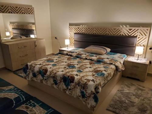 a bedroom with a large bed and a mirror at Stylish 3 bedroom apartment close to the Pyramids and Grand Egyptian Museum in ‘Ezbet `Abd el-Ḥamîd