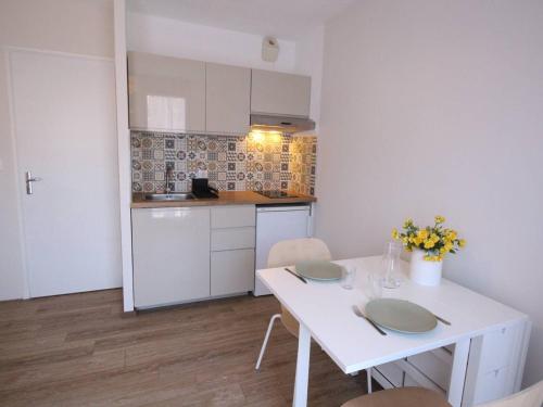 une petite cuisine avec une table et des chaises blanches dans l'établissement Studio Central 2 Pers, Parking, Proche Thermes & Commerces - FR-1-313-156, à Luchon