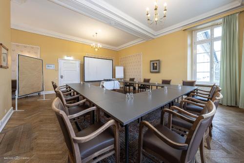 a conference room with a large table and chairs at Schlosshotel Westerholt in Herten