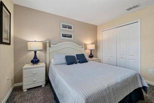um quarto com uma cama com almofadas azuis e 2 candeeiros em Lovely new Townhome paradise em Kissimmee