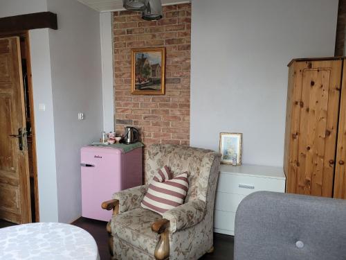 a living room with a chair and a pink refrigerator at DOM GOŚCINNY PTASZARNIA - NATURA-Free PARKING in Świnoujście