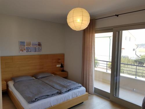 een slaapkamer met een bed en een groot raam bij Villa Arbatica in Barbat na Rabu