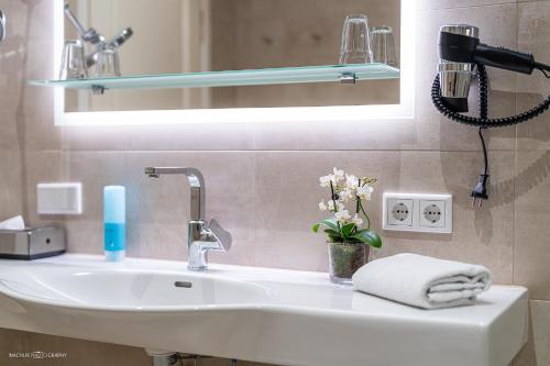 a bathroom with a sink and a mirror at Schlosshotel Westerholt in Herten