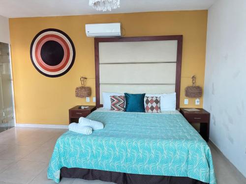 a bedroom with a large bed with a blue comforter at Suites Valentina in Puerto Morelos