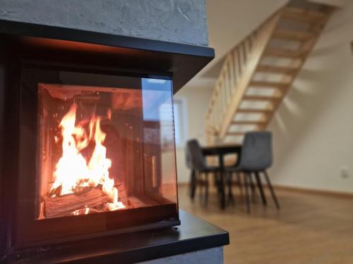 a fireplace in a living room with a fire in it at Rodinný dům u rybníka v blízkosti Olomouce in Hlušovice