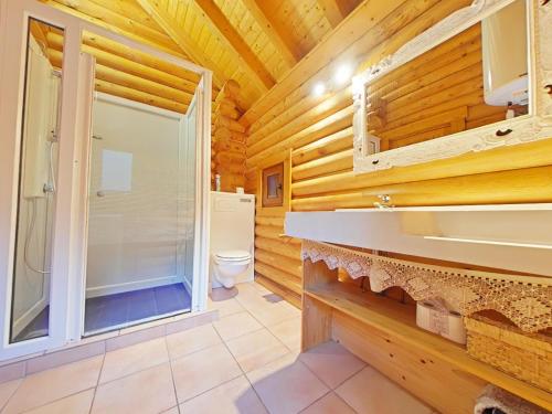 a log cabin bathroom with a shower and a toilet at Au chalet de La Burotte in Basse-sur-le-Rupt