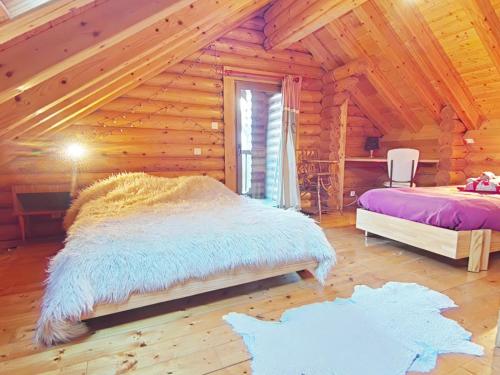 a bedroom with two beds in a log cabin at Au chalet de La Burotte in Basse-sur-le-Rupt
