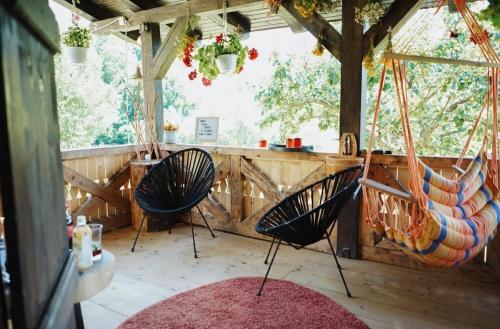 two chairs in a room with a hammock at Cuibul cu Trufe in Feldru