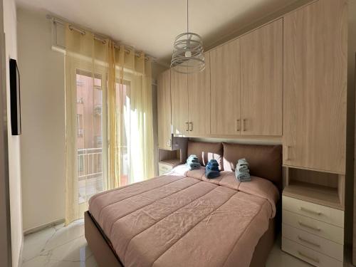 a bedroom with a large bed and a window at Dolce Vita A 5 Minuti Dal Centro Con Parcheggio Privato Gratuito in Sanremo