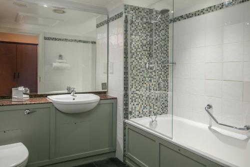 a bathroom with a sink and a shower and a toilet at Belton Woods Hotel, Spa & Golf Resort in Grantham