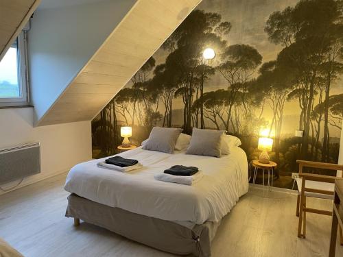 a bedroom with a large bed with a painting on the wall at Gîte de Masne in Courbouzon