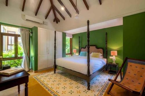 - une chambre avec un lit et un mur vert dans l'établissement Villa Beheira, à Damanhûr