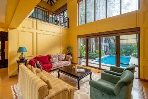 Villa Beheira في Damanhûr: غرفة معيشة مع أريكة وطاولة ومسبح