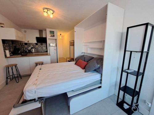 1 dormitorio pequeño con 1 cama y cocina en Studio Marseillan-Plage, 1 pièce, 4 personnes - FR-1-326-781, en Marseillan