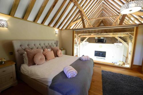 a bedroom with a large bed with pillows on it at Forest Farm Barn Hampshire in Bishops Waltham