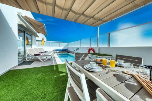 een open woonkamer met een eettafel en een zwembad bij Villa Cassia - Private Pool, Foosball, BBQ, Air-Con and SAT Tv By Lanzarote Vacation Homes in Playa Blanca