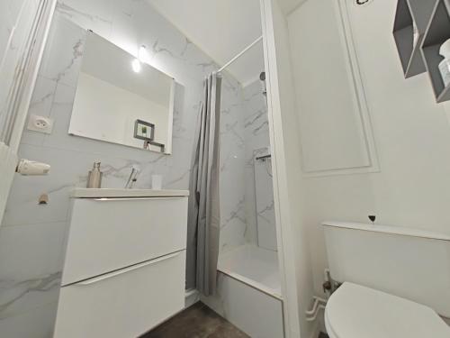 a white bathroom with a shower and a toilet at Le 307, Vue pistes in La Bresse
