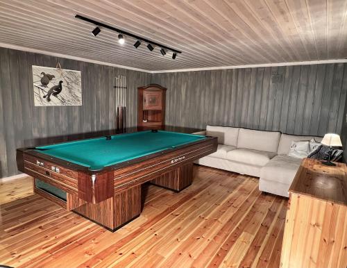 a living room with a pool table and a couch at Stor og flott hytte med fantastisk utsikt in Geilo