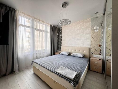 1 dormitorio con cama y ventana grande en 45 Pearl Magnificent Apartment, en Odessa