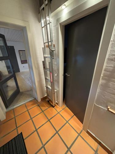 a hallway with a door and a tiled floor at Vroldvej in Skanderborg