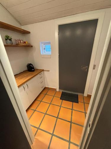 een keuken met een deur en een tegelvloer bij Vroldvej in Skanderborg