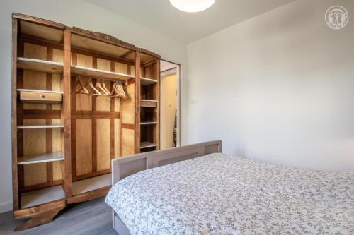 Chez nicole et alain في يوجين: غرفة نوم بسرير وخزانة خشبية