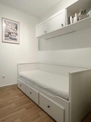 a bed in a room with white walls at Charmant studio neuf proche de paris in Bagnolet