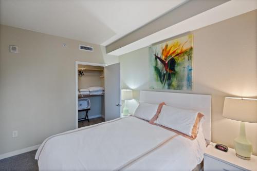a bedroom with a white bed and a painting on the wall at Global Luxury Suites San Jose Downtown in San Jose