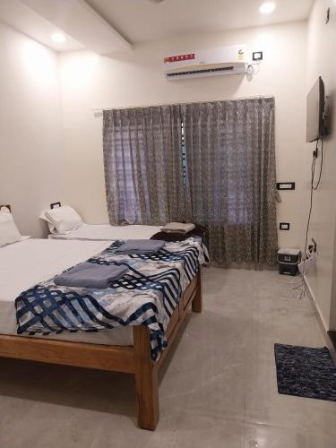 a bedroom with a bed in front of a window at Padmaa Hampi Echo Villa in Hampi