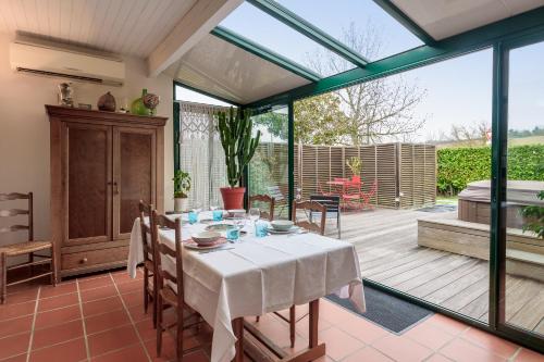 d'une salle à manger avec une table et des portes en verre. dans l'établissement L'Orinss - Maison avec jacuzzi, à Saint-Orens-de-Gameville