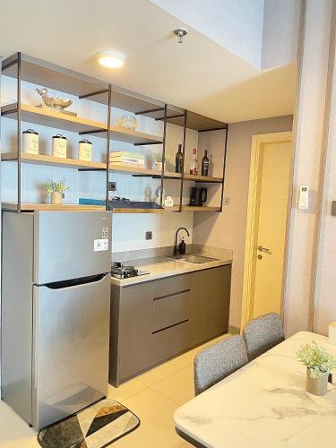 a kitchen with a sink and a stainless steel refrigerator at 2 BR I ANDERSON I 18floor I above pakuwon mall I the biggest shopping center in Surabaya