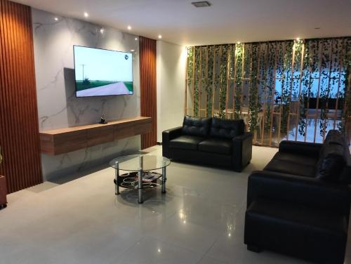 uma sala de estar com 2 sofás e uma televisão de ecrã plano em Hotel Chico Real em Bucaramanga