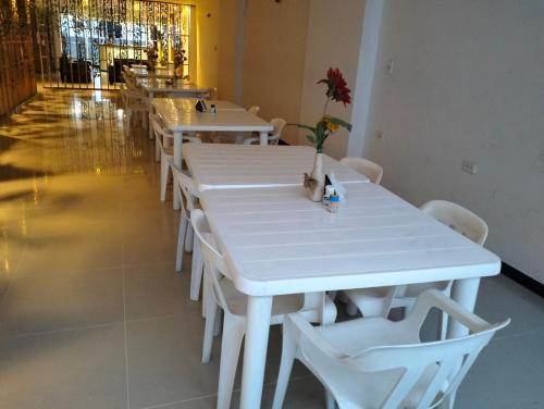 uma fila de mesas e cadeiras brancas num restaurante em Hotel Chico Real em Bucaramanga