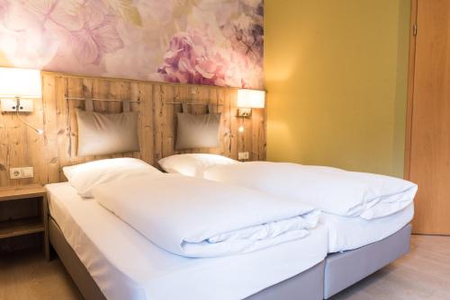 two beds in a room with a painting on the wall at Landgasthof Zum Goldenen Anker in Eggenstein-Leopoldshafen