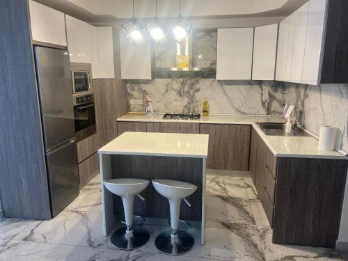 a kitchen with a counter and stools in it at Palm Haven - Boutique Gozo Maisonette in Munxar