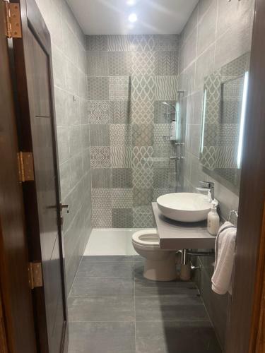 een badkamer met een wastafel, een toilet en een douche bij Maisonette 2 in Munxar