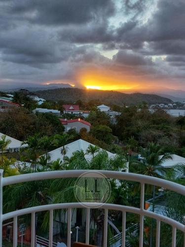 a view of the sunset from the balcony of a resort at LittleLovely Studio in La Trinité